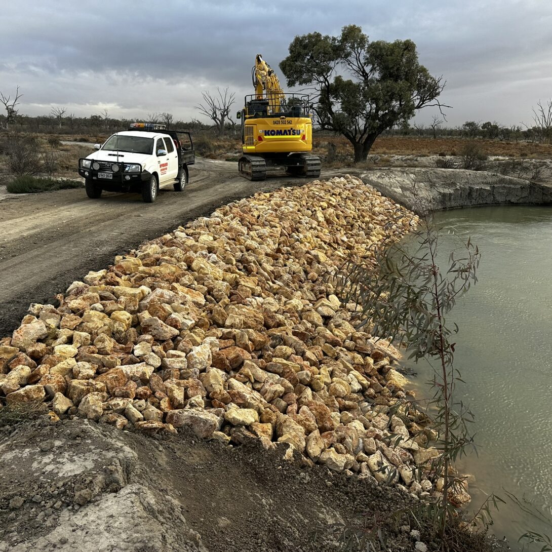 Leed - Image shows white work ute travelling past construction machinery next to the wetland