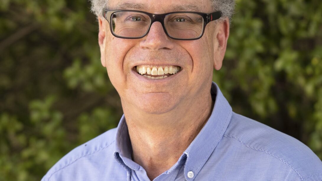 Leed - Leed co-founder and current Board Chairman is pictured with a green, tree background and a blue shirt